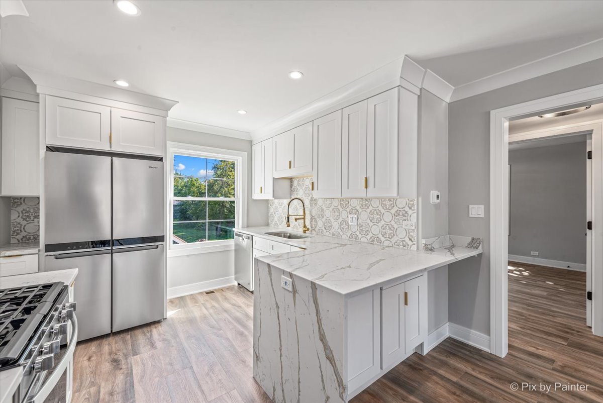 229 West Harding Road Lombard, IL 60148 - Photo 5 of 29 a kitchen with a sink a stove a refrigerator and white cabinets with wooden floor