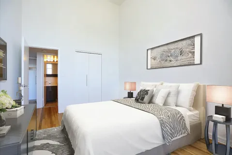 a bedroom with a bed and wooden floor