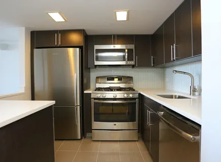 a kitchen with stainless steel appliances granite countertop a refrigerator stove and sink