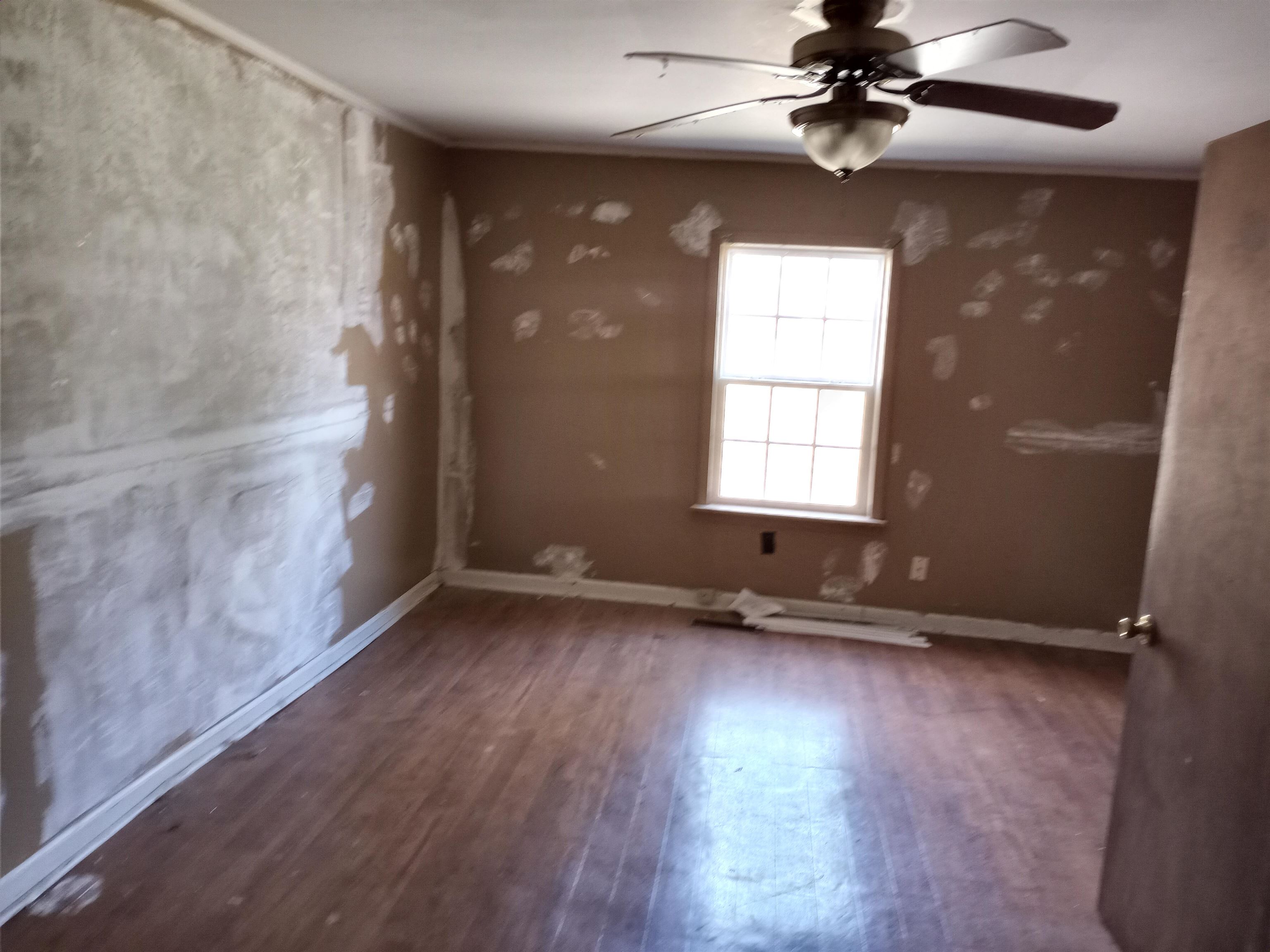417 West Ripley Avenue Covington, TN 38019 - Photo 5 of 7 a view of an empty room with a window and wooden floor