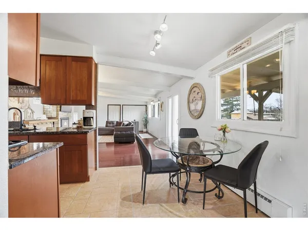 a living room with furniture a clock on wall and a window