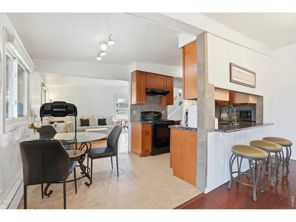 a living room with furniture a flat screen tv and kitchen view