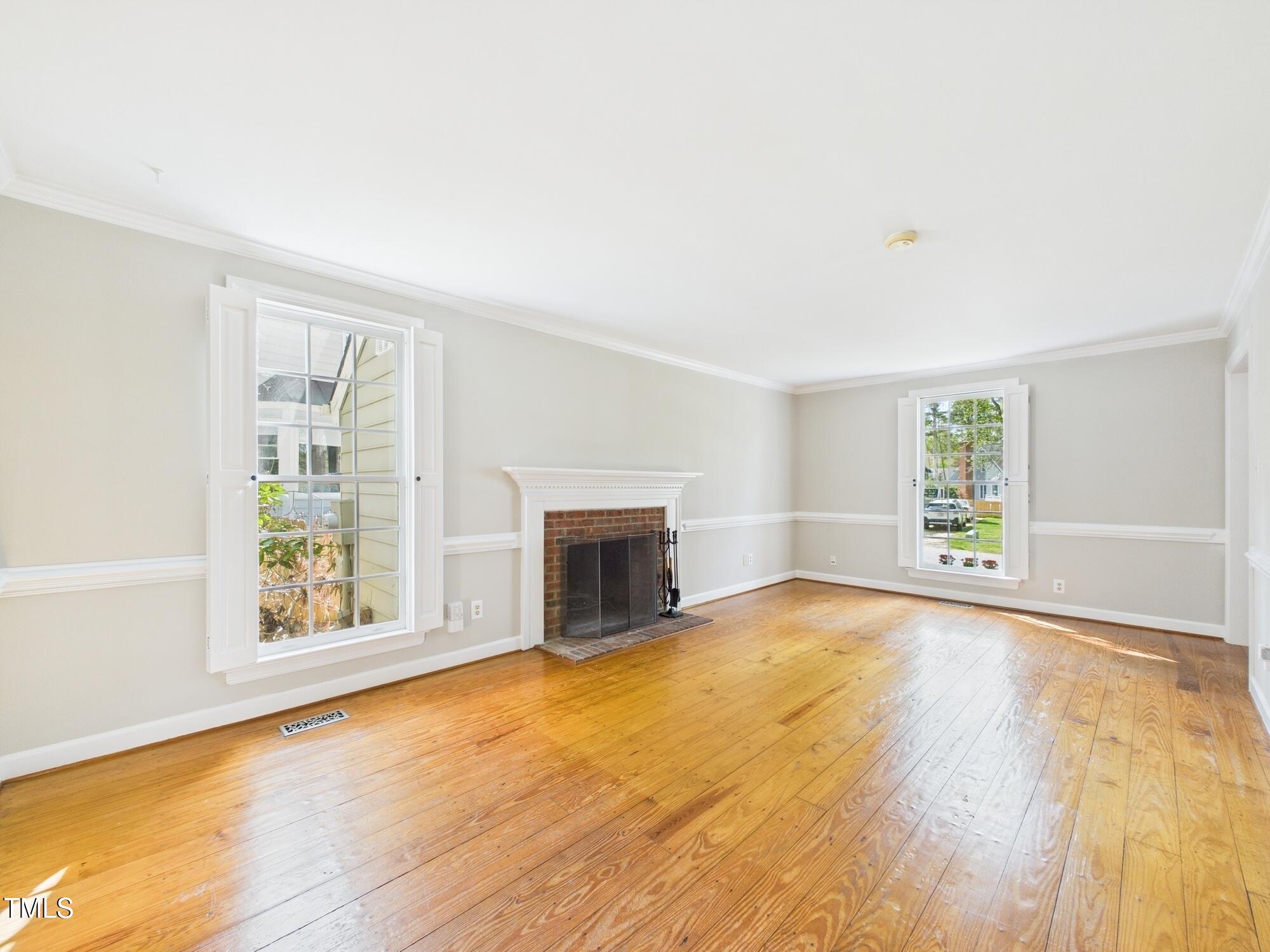 7117 Sandringham Drive Raleigh, NC 27613 - Photo 15 of 54 a view of an empty room with a window and fireplace