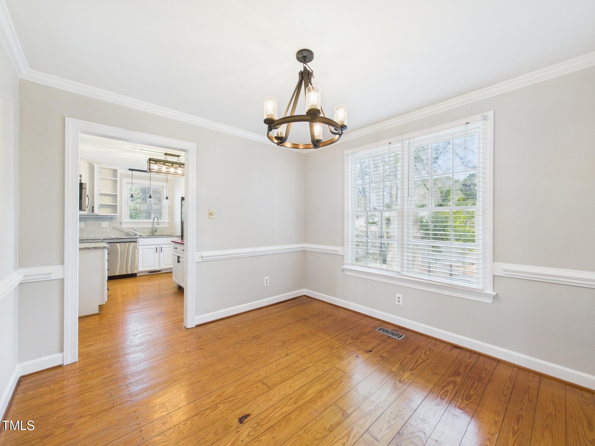 7117 Sandringham Drive Raleigh, NC 27613 - Photo 16 of 54 a view of a livingroom with wooden floor and a window