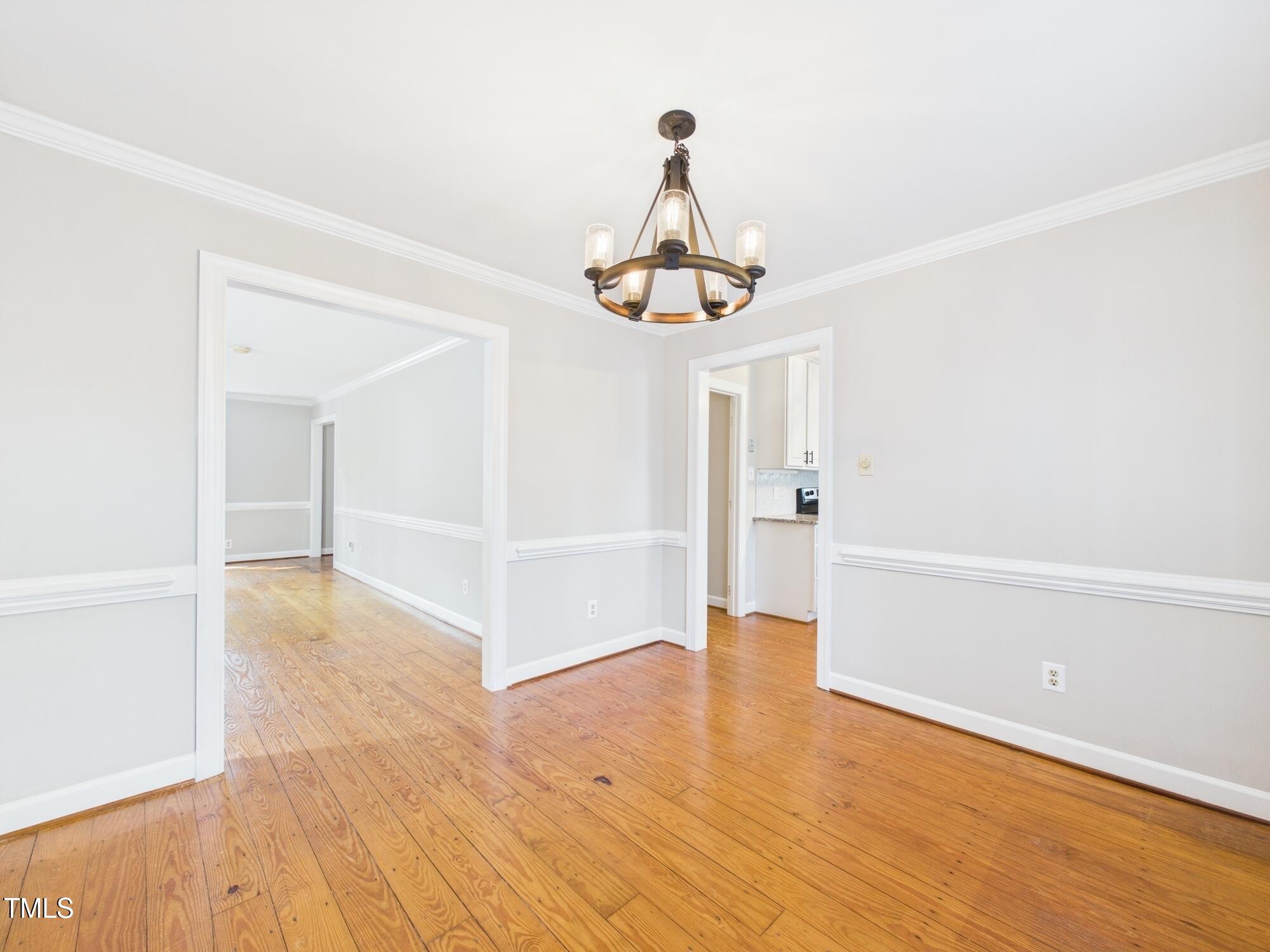 7117 Sandringham Drive Raleigh, NC 27613 - Photo 17 of 54 a view of empty room with wooden floor and ceiling fan