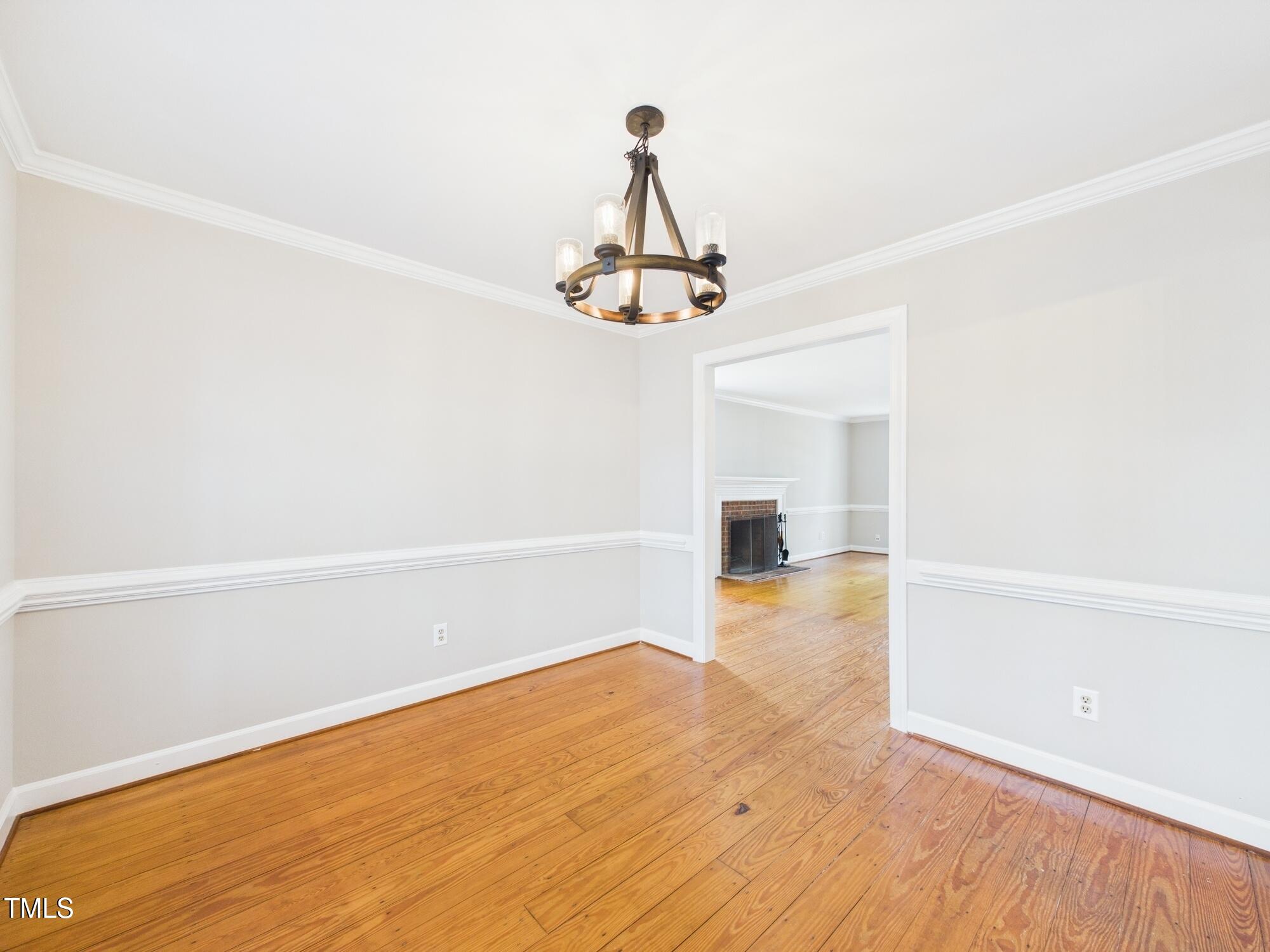 7117 Sandringham Drive Raleigh, NC 27613 - Photo 18 of 54 a view of a room with wooden floor and a ceiling fan