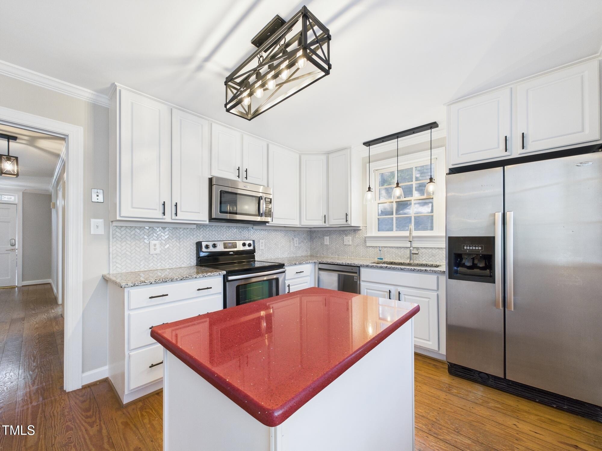 7117 Sandringham Drive Raleigh, NC 27613 - Photo 21 of 54 a kitchen with stainless steel appliances granite countertop a refrigerator a sink dishwasher a stove top oven a refrigerator with grey cabinets and wooden floor
