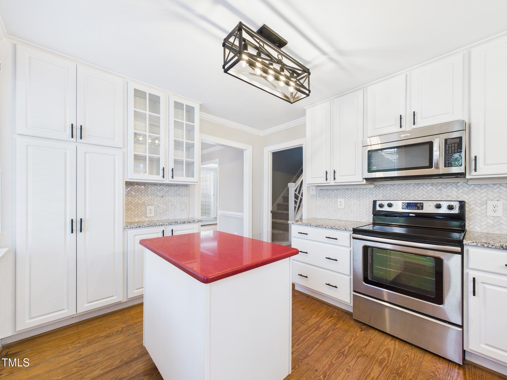 7117 Sandringham Drive Raleigh, NC 27613 - Photo 22 of 54 a kitchen with stainless steel appliances a stove microwave and cabinets