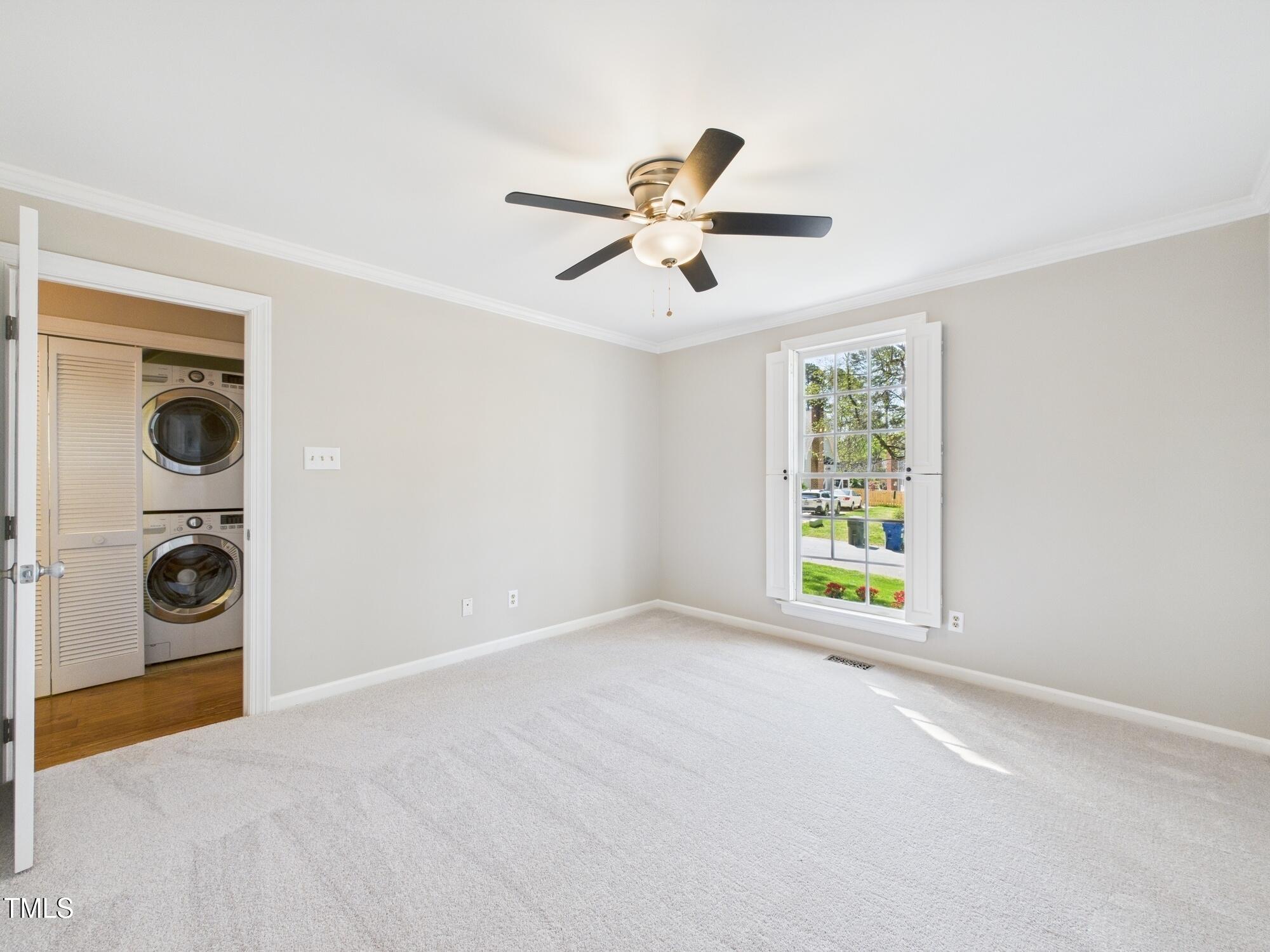 7117 Sandringham Drive Raleigh, NC 27613 - Photo 28 of 54 a view of an empty room with a window and a fan