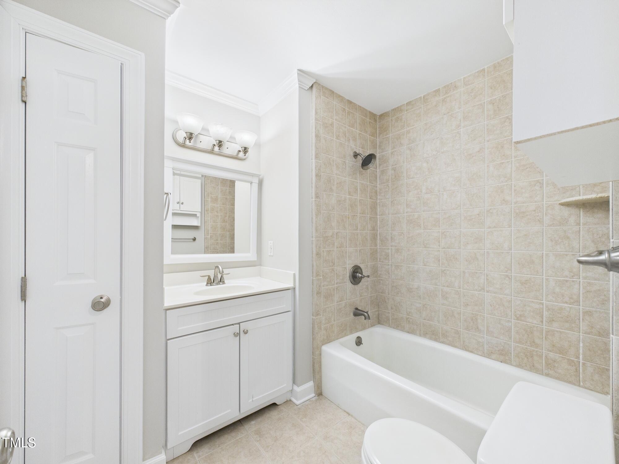 7117 Sandringham Drive Raleigh, NC 27613 - Photo 30 of 54 a bathroom with a tub a sink and a mirror