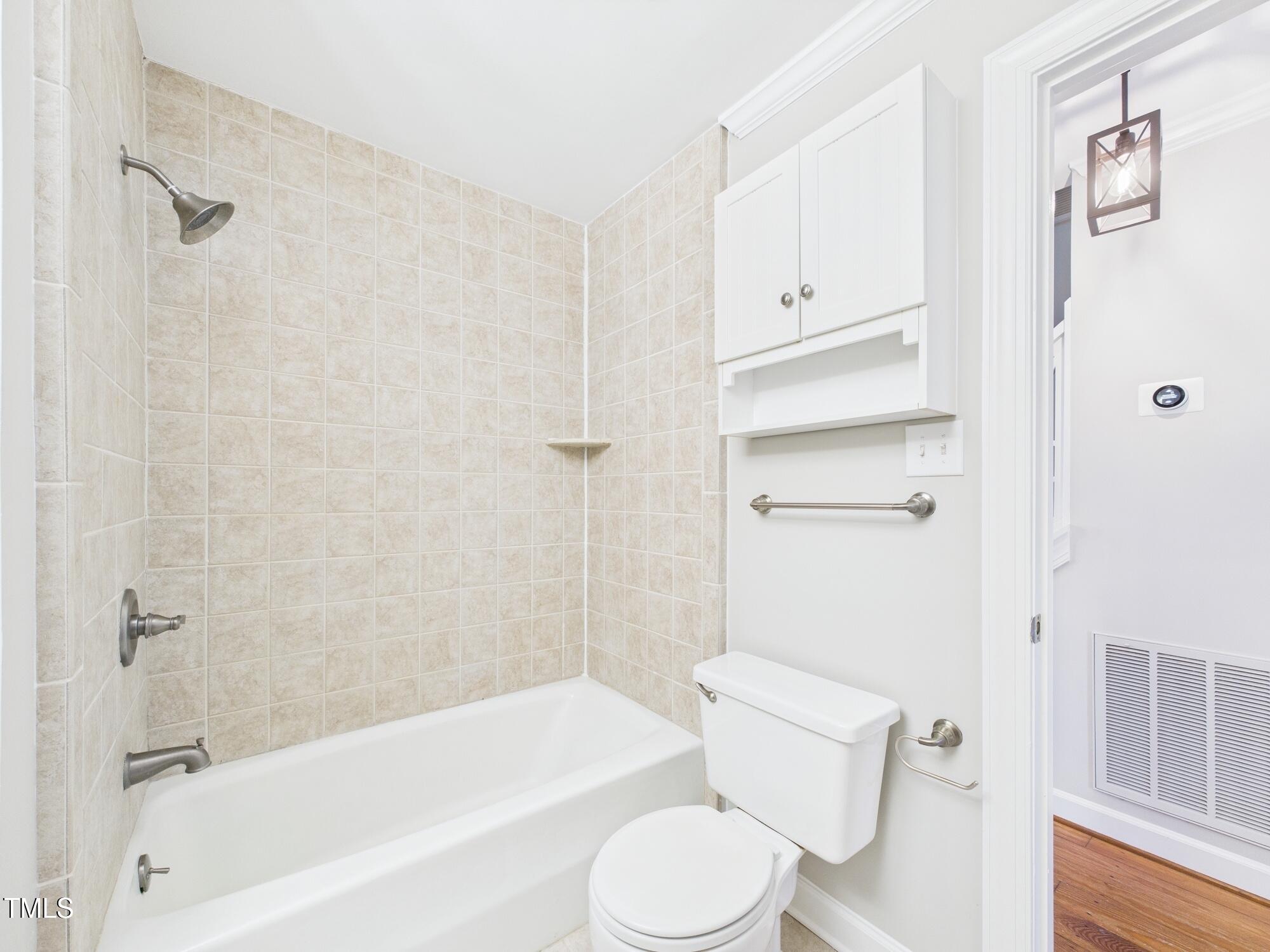 7117 Sandringham Drive Raleigh, NC 27613 - Photo 31 of 54 a white toilet sitting next to a bath tub