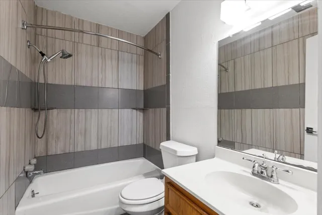 an empty room with wooden floor chandelier fan and windows