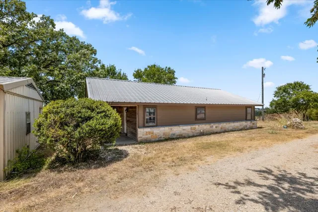 a view of a house with a yard and large tree