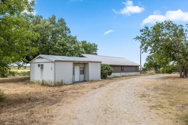 a dirt road with an house in background