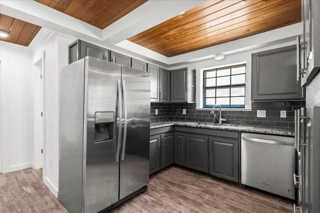 a kitchen with stainless steel appliances granite countertop a sink stove and refrigerator