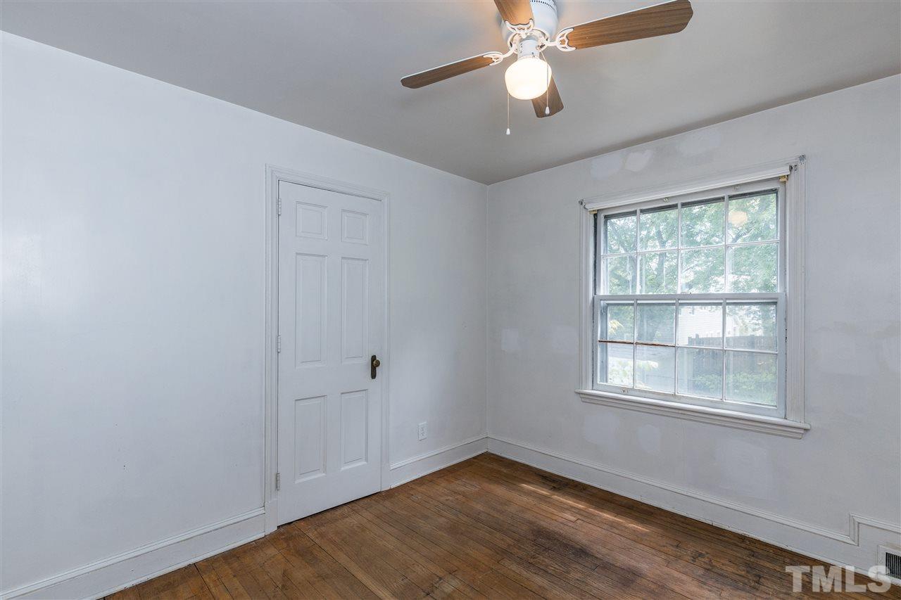 614 Elm Street Raleigh, NC 27604 - Photo 19 of 30 an empty room with wooden floor chandelier fan and windows