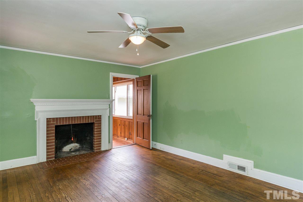 614 Elm Street Raleigh, NC 27604 - Photo 8 of 30 a view of an empty room with wooden floor and a fireplace