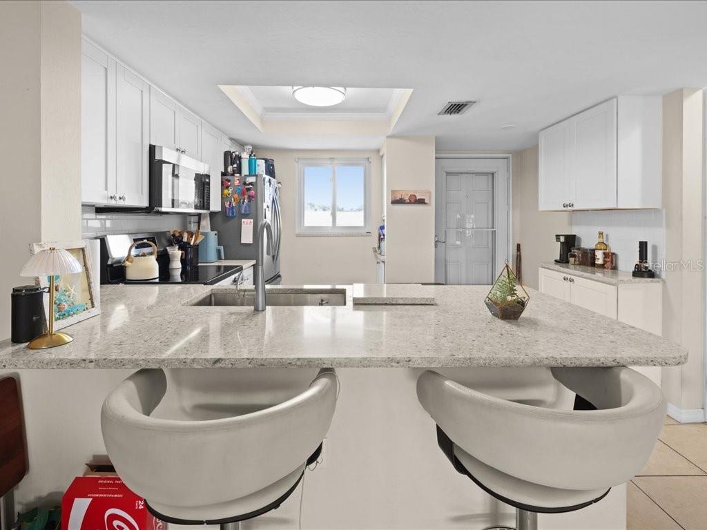 25275 Rampart Boulevard, Unit 1607 Punta Gorda, FL 33983 - Photo 5 of 23 a kitchen with a sink and a stove with wooden floor