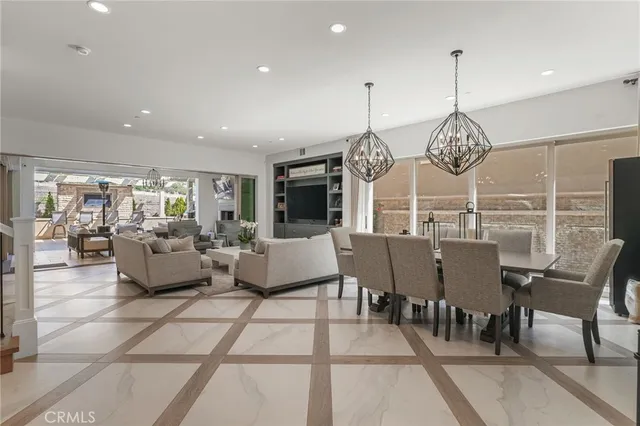 a view of a dining room and livingroom with furniture wooden floor a chandelier