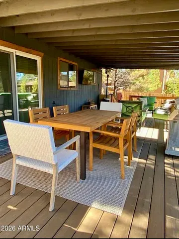 a view of a patio with table and chairs with wooden floor and fence