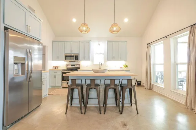 a bedroom with a bed chandelier and a window