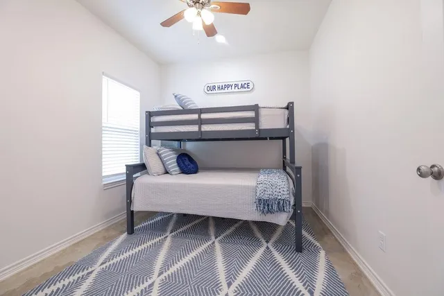 a spacious bedroom with a bed and a rug