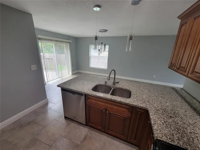 a kitchen with granite countertop a sink and a window