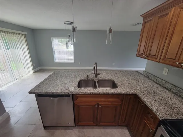 a kitchen with granite countertop cabinets sink and window