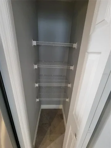 a view of walk in closet with empty racks