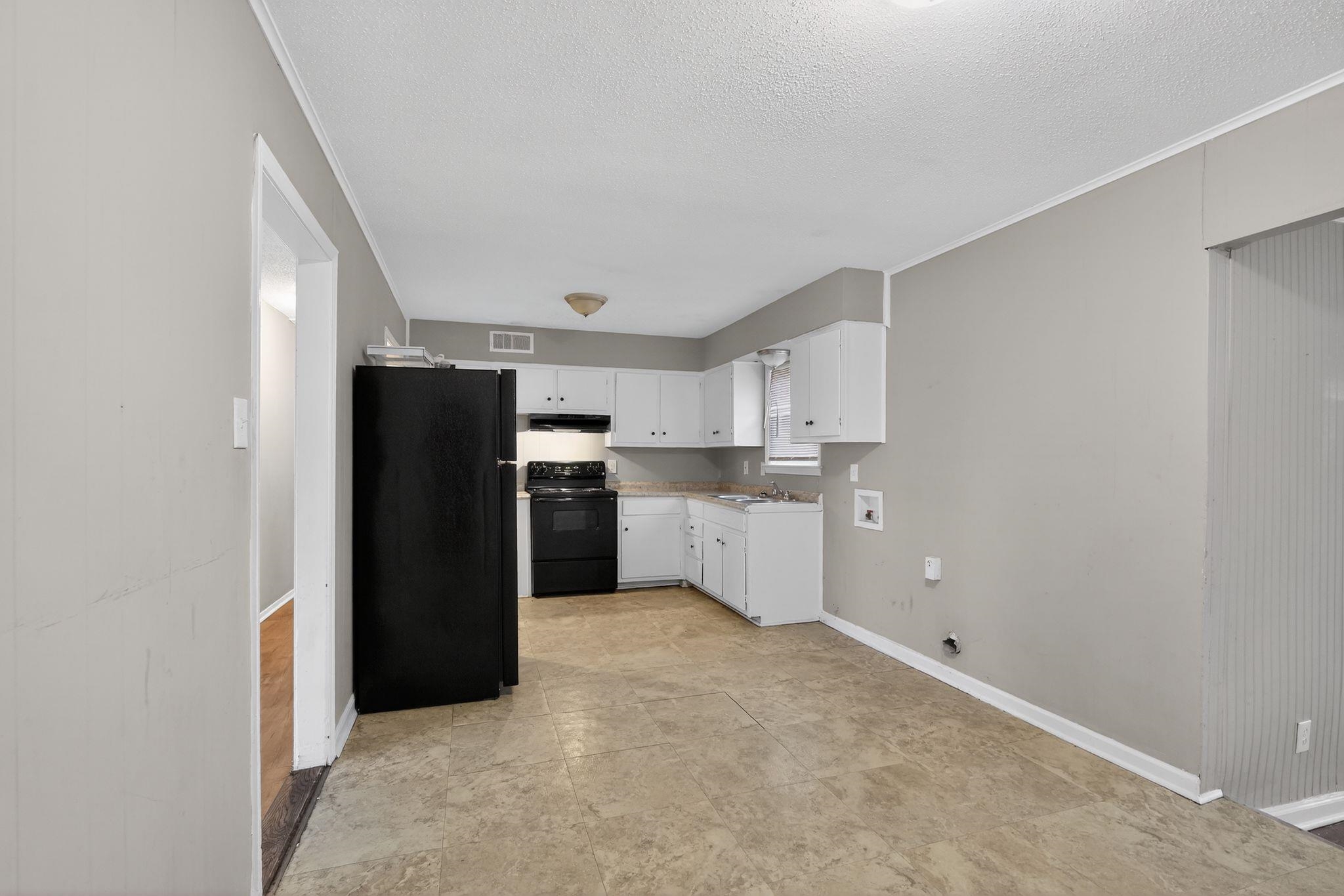 4314 Ford Road Memphis, TN 38109 - Photo 19 of 31 a kitchen with a refrigerator and white cabinets