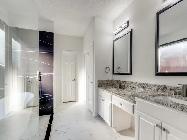 a spacious bathroom with a granite countertop sink and a mirror