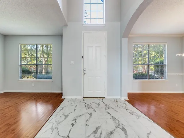a view of a bedroom with wooden floor and windows