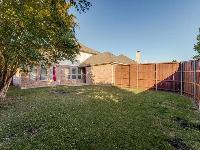 a view of backyard with small cabin and wooden fencing