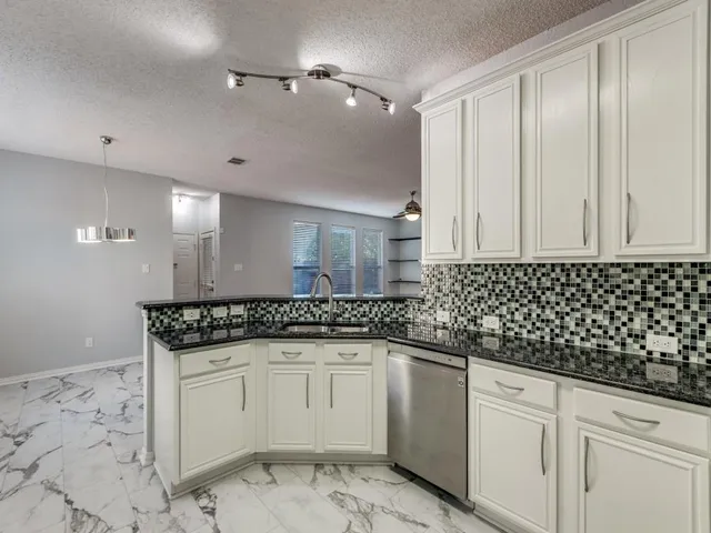 a spacious bathroom with a granite countertop sink and a mirror