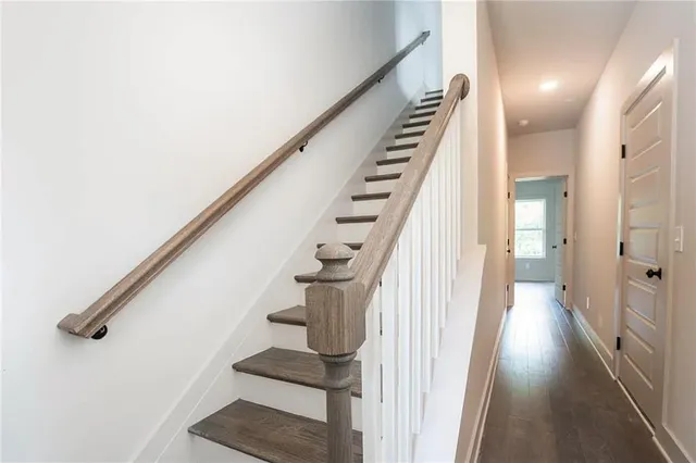 a view of staircase with lots of frames on wall and wooden floor