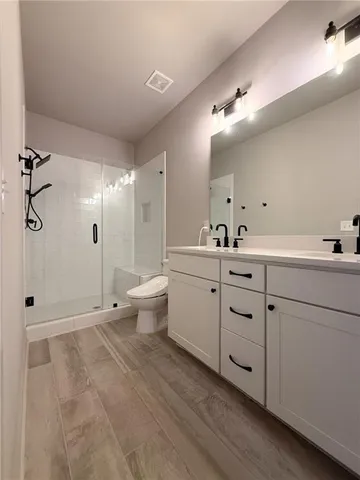 a bathroom with a double vanity sink toilet and shower