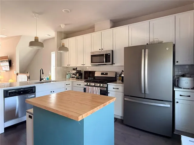 a kitchen with a refrigerator a microwave a sink and a stove