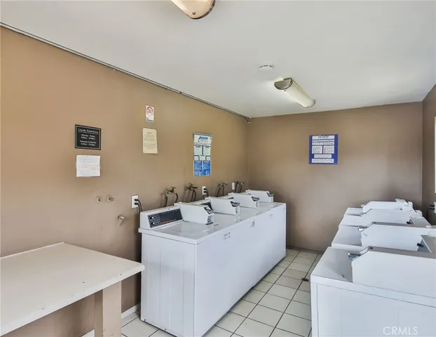 a view of a white house with a yard and table and chairs