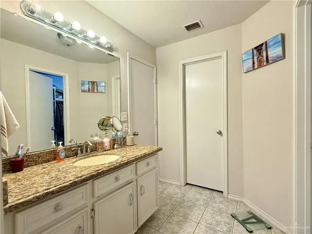 a bathroom with a granite countertop sink and a mirror