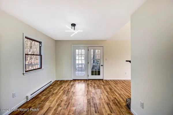 a kitchen with stainless steel appliances granite countertop a stove top oven a sink dishwasher a dining table and chairs with wooden floor