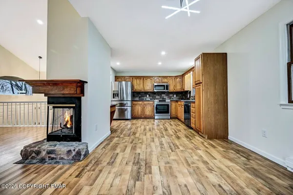 a open kitchen with granite countertop a stove top oven a sink and dishwasher with wooden floor