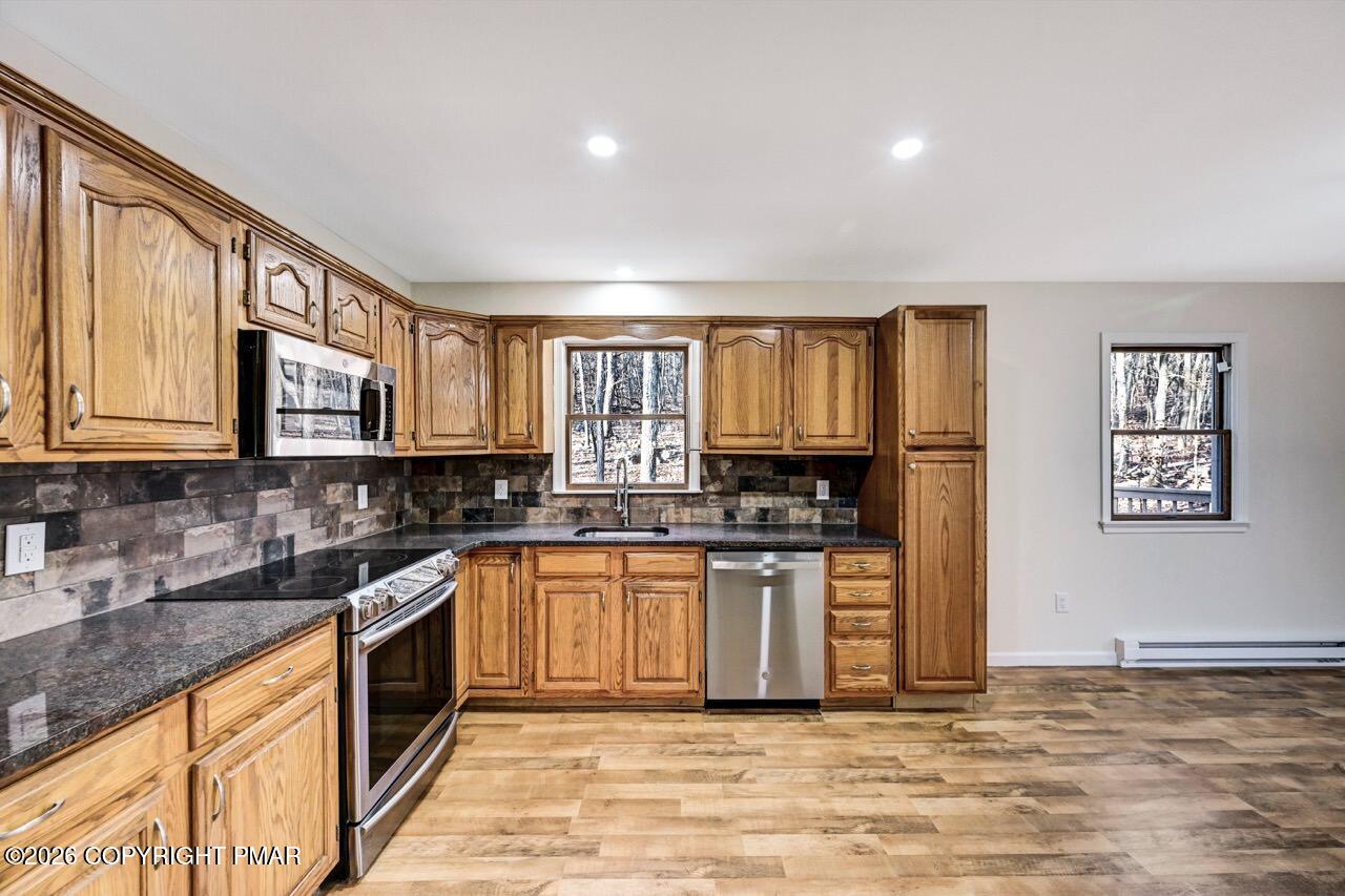 171 Foothill Boulevard Effort, PA 18330 - Photo 19 of 61 a kitchen with stainless steel appliances granite countertop a stove top oven a sink dishwasher a dining table and chairs with wooden floor
