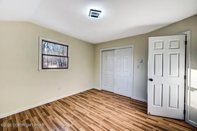 a view of empty room with wooden floor