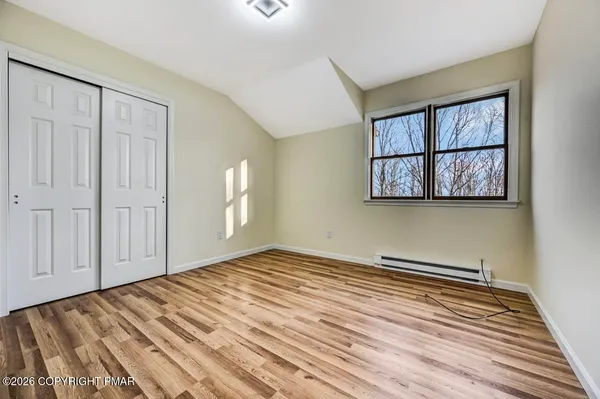 a view of empty room with wooden floor