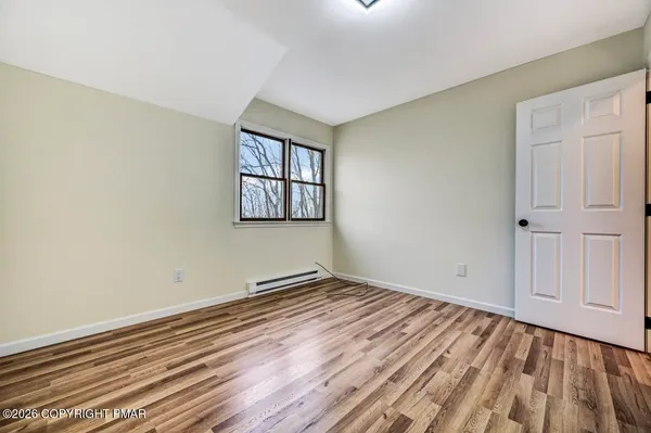 a view of an empty room with wooden floor