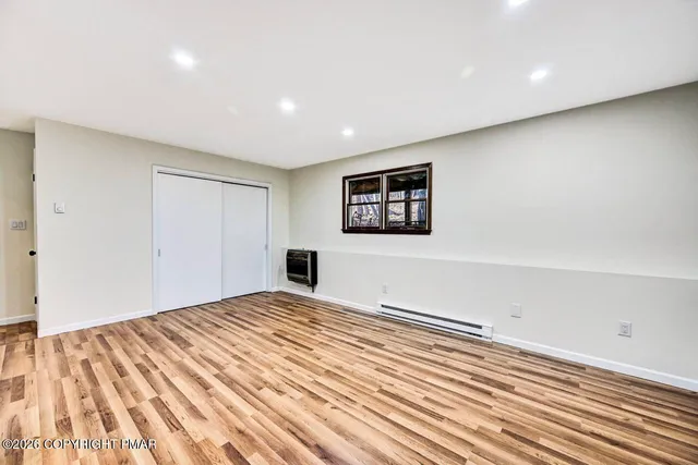 a view of a hallway with wooden floor and entryway