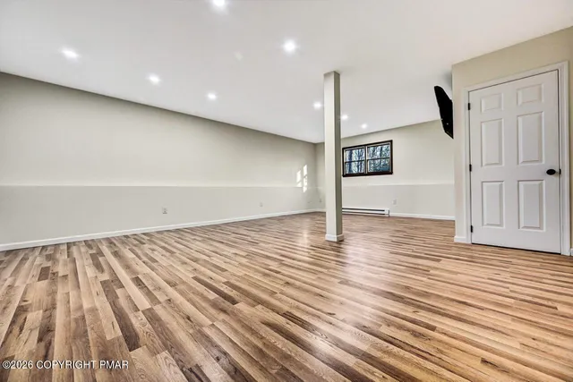 a view of a hallway with wooden floor and entryway