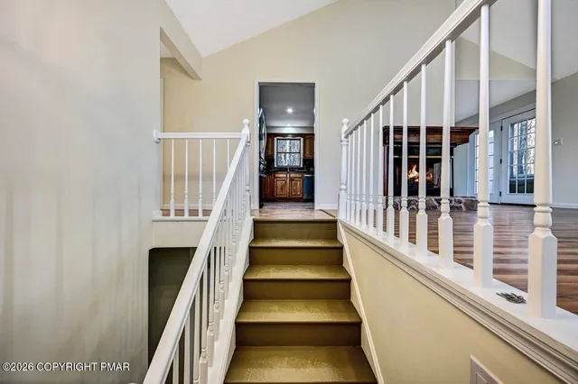 a view of staircase with lots of frames on wall and a window