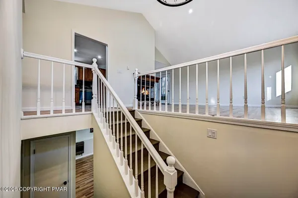 a view of staircase with railing and white walls