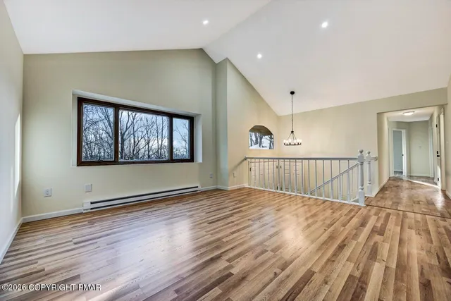 a view of empty room with wooden floor and fireplace
